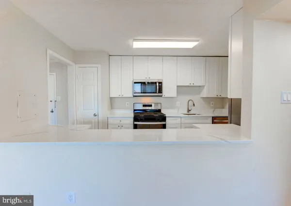 a kitchen with granite countertop a stove and a refrigerator