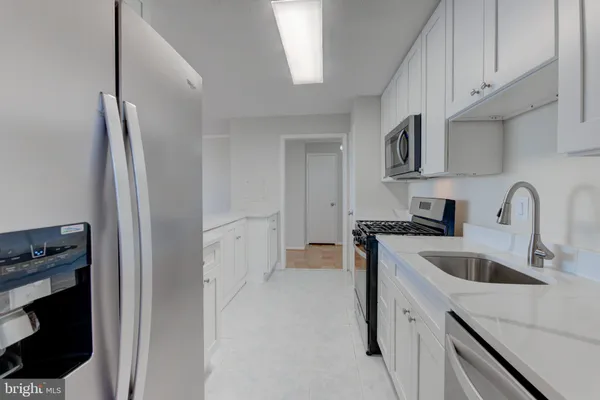 a kitchen with stainless steel appliances granite countertop a refrigerator and a sink