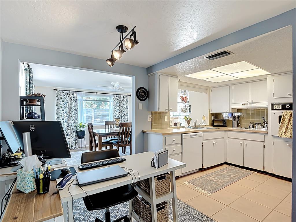 9420 Cochise Lane Port Richey, FL 34668 - Photo 11 of 47 a kitchen with sink cabinets and dining table