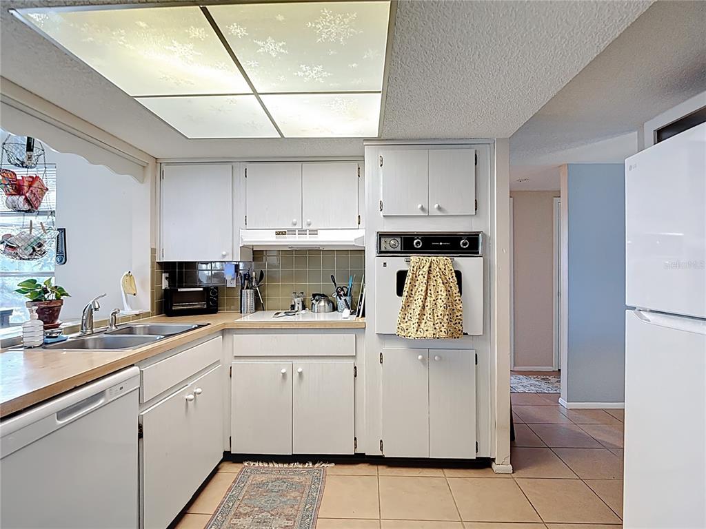 9420 Cochise Lane Port Richey, FL 34668 - Photo 16 of 47 a kitchen with a white cabinets and refrigerator
