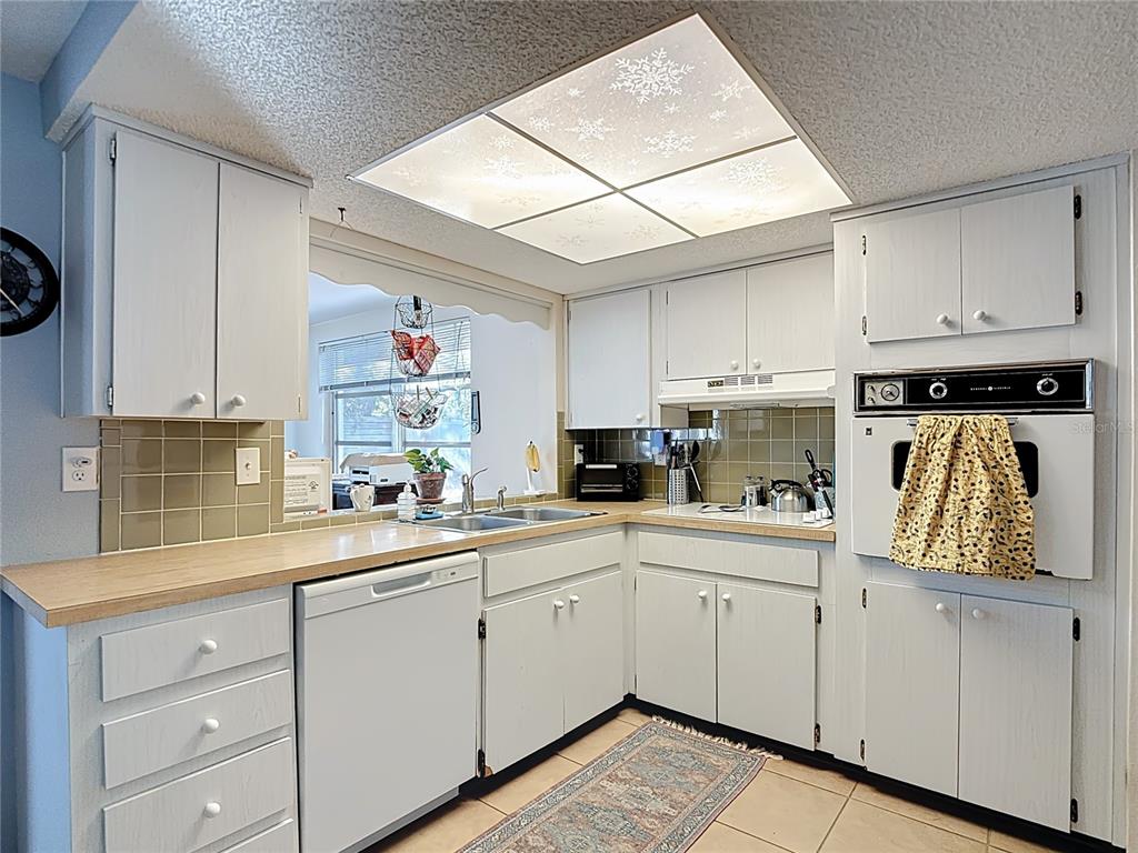 9420 Cochise Lane Port Richey, FL 34668 - Photo 17 of 47 a kitchen with white cabinets and white appliances