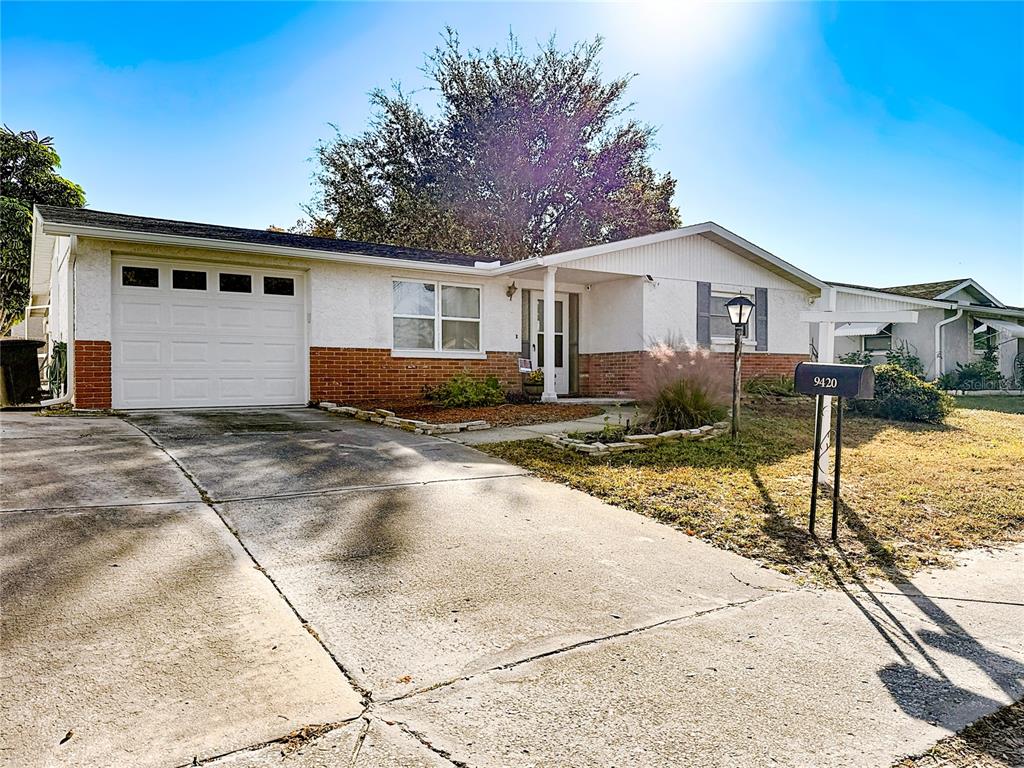 9420 Cochise Lane Port Richey, FL 34668 - Photo 47 of 47 a view of a house with a yard and large trees