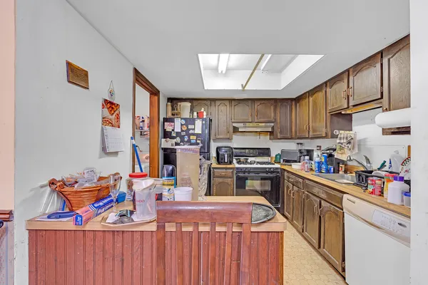 a open kitchen with stainless steel appliances granite countertop a stove top oven a sink dishwasher and cabinets with wooden floor