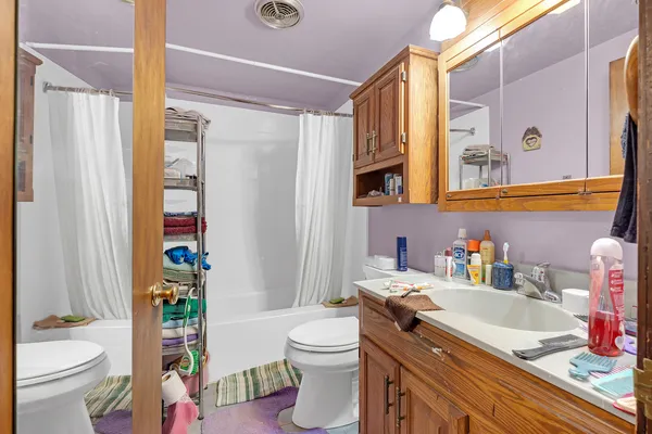 a bathroom with a sink a toilet and shower curtain