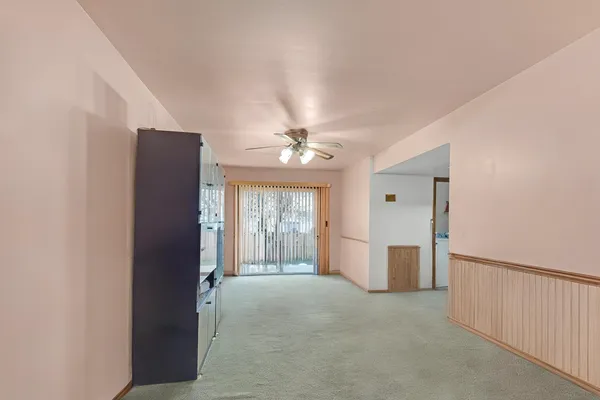 en empty room with windows and ceiling fan