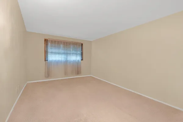 an empty room with window in closet and wooden floor