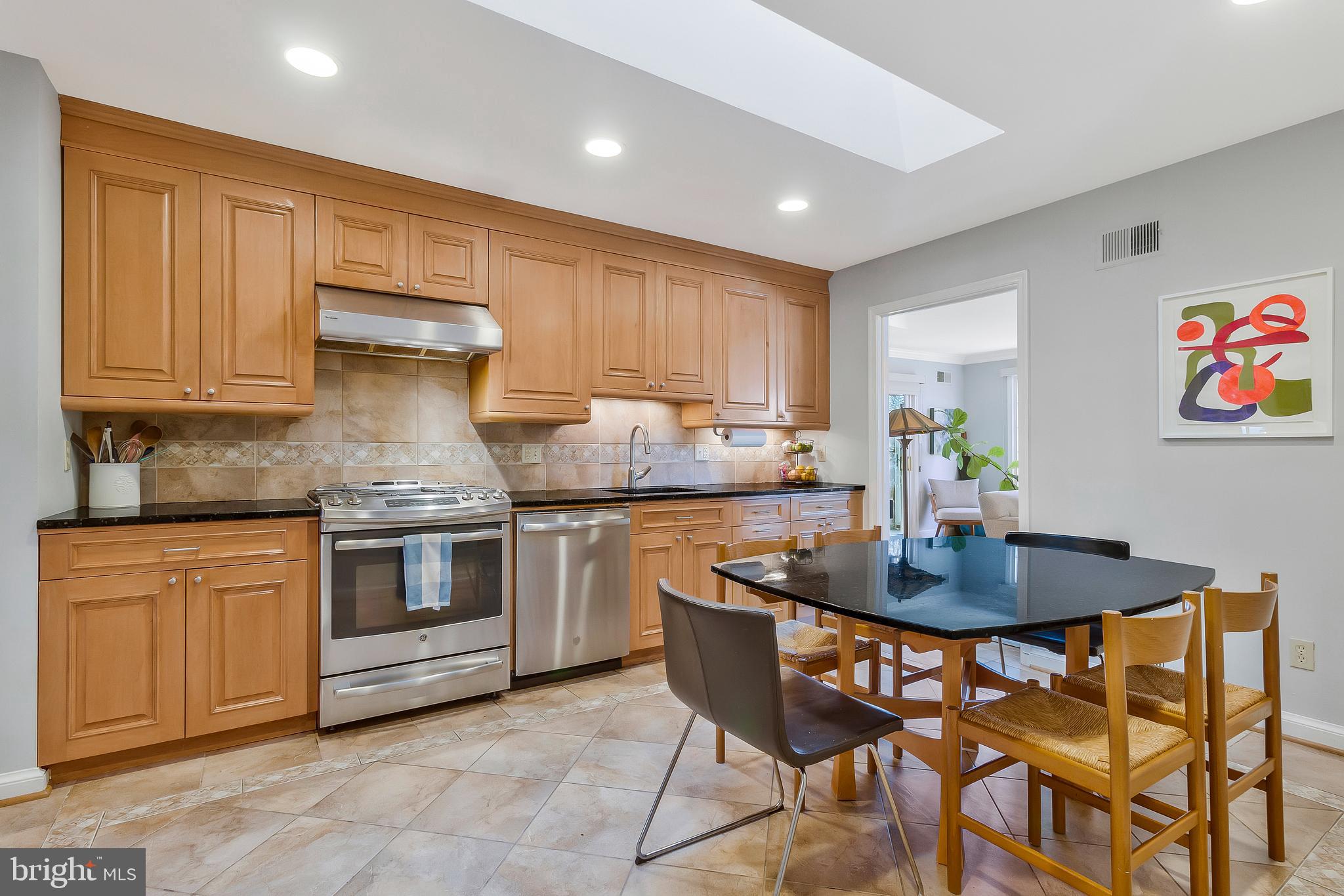 2812 Greenvale Street Chevy Chase, MD 20815 - Photo 10 of 27 a kitchen with granite countertop a table chairs stove and cabinets
