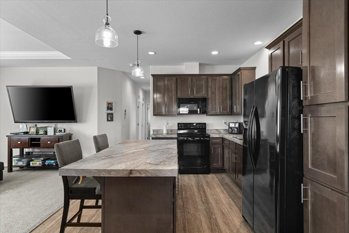 4399 Aplicella Court, Unit 75 Manteca, CA 95337 - Photo 16 of 30 a kitchen with stainless steel appliances wooden floor and a refrigerator