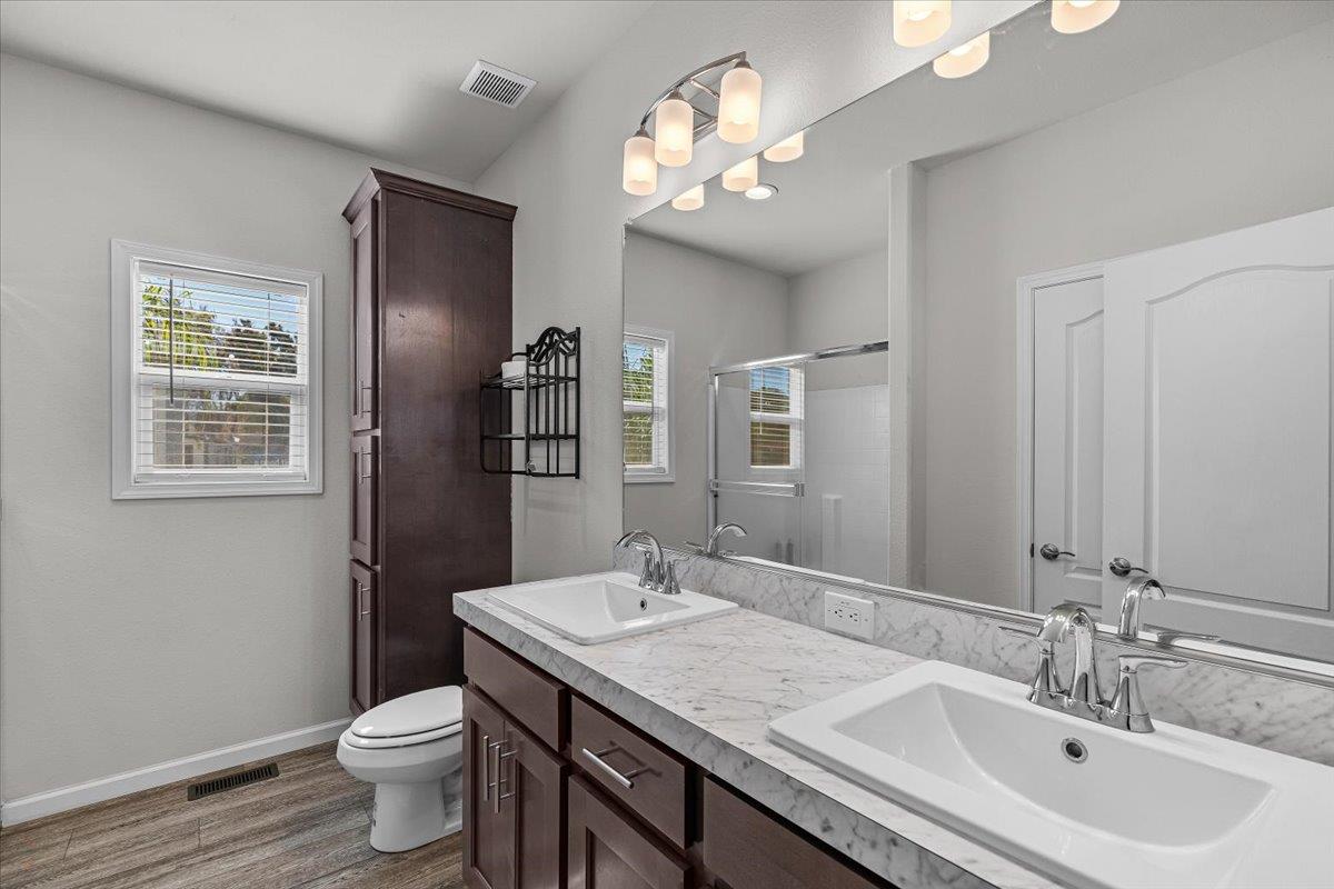 4399 Aplicella Court, Unit 75 Manteca, CA 95337 - Photo 25 of 30 a bathroom with a granite countertop sink a toilet and a mirror