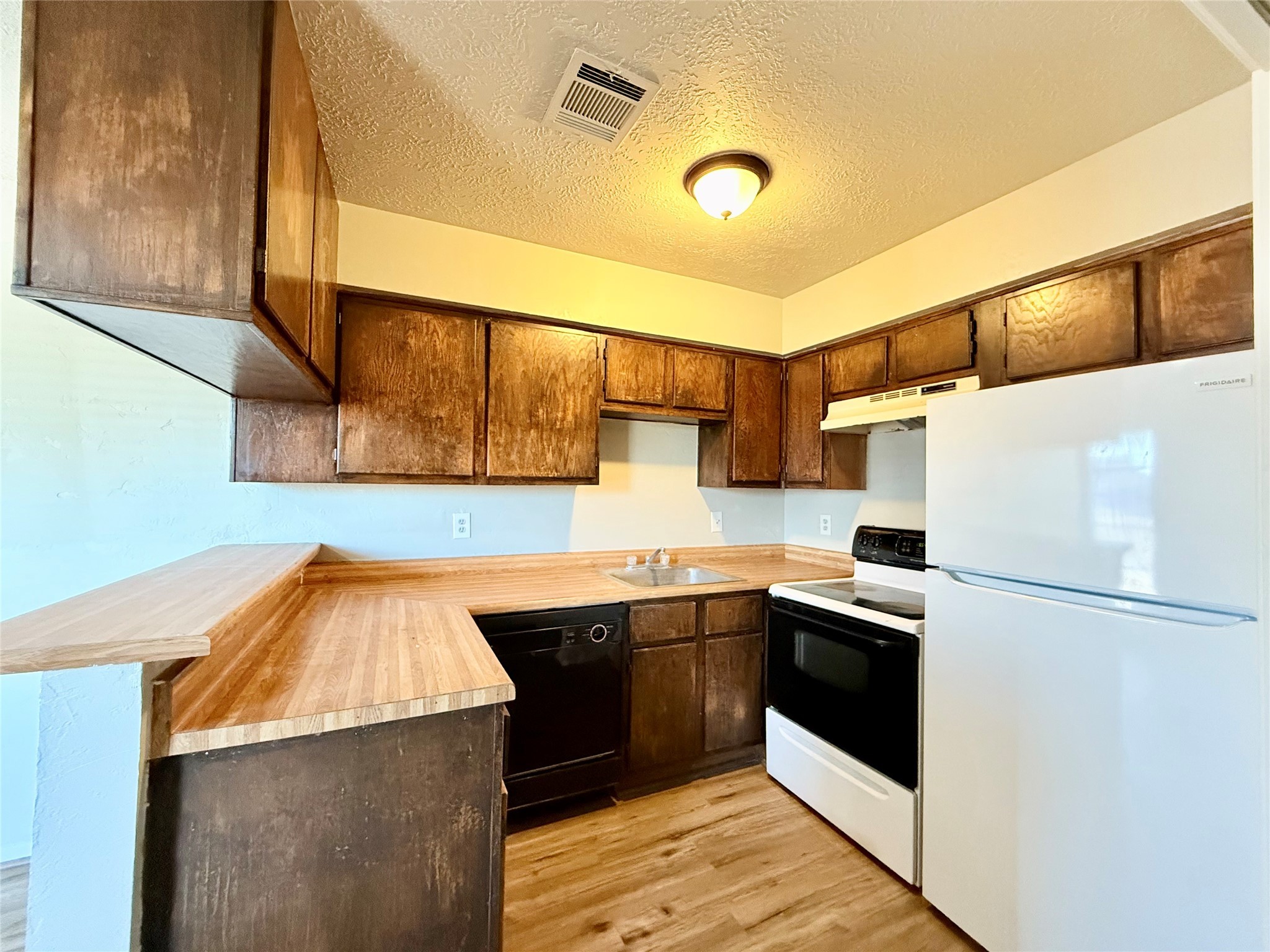 705 Ruth Court, Unit B Navasota, TX 77868 - Photo 5 of 14 a kitchen with stainless steel appliances granite countertop a sink and a refrigerator
