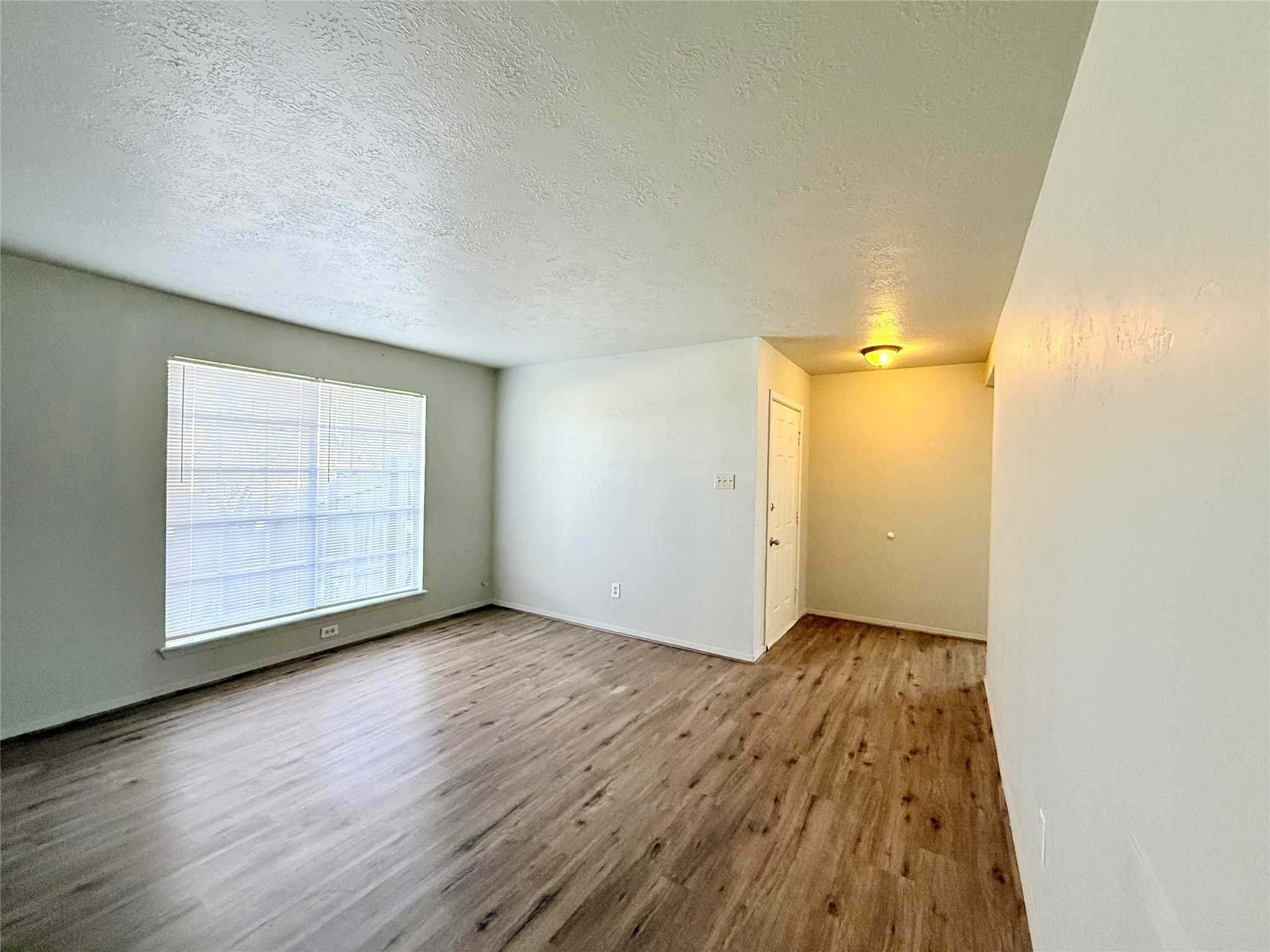 705 Ruth Court, Unit B Navasota, TX 77868 - Photo 7 of 14 an empty room with wooden floor and windows