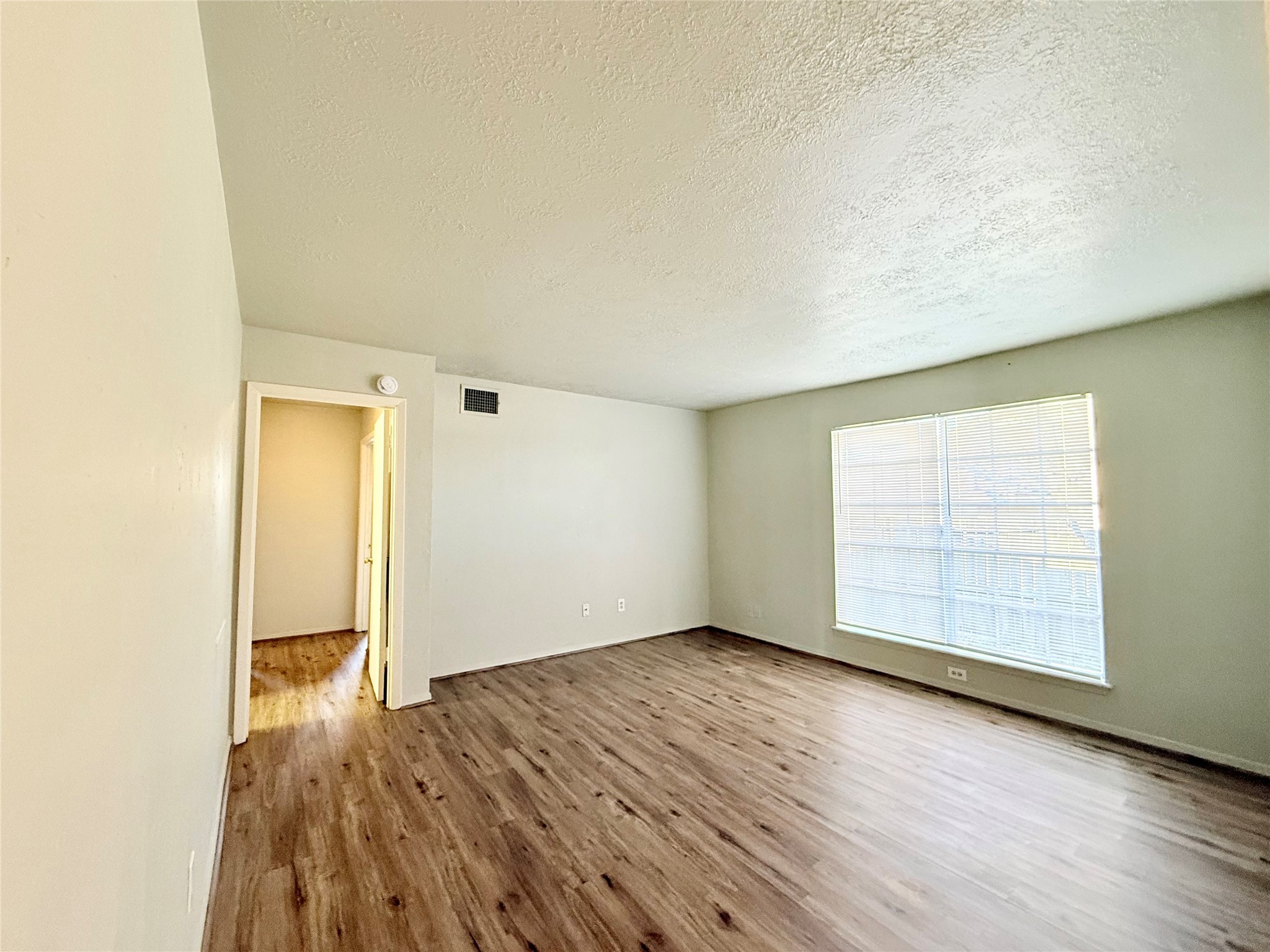 705 Ruth Court, Unit B Navasota, TX 77868 - Photo 8 of 14 an empty room with wooden floor and windows