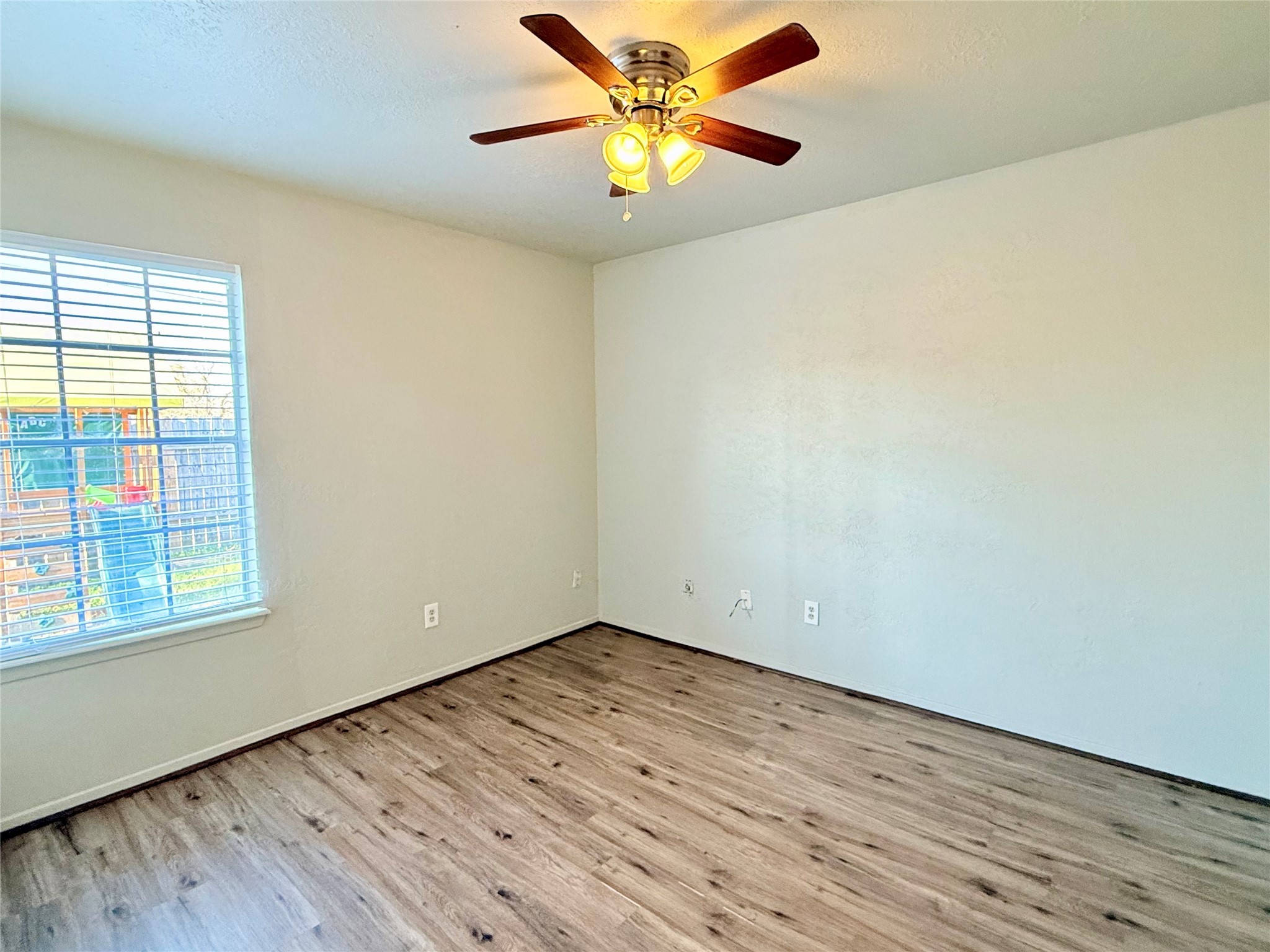 705 Ruth Court, Unit B Navasota, TX 77868 - Photo 10 of 14 a view of an empty room with window and wooden floor