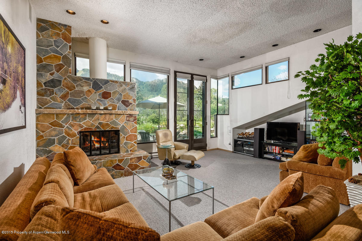 a living room with furniture a fireplace and a large window