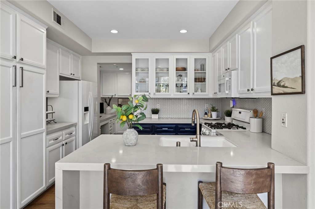 36 Tuberose Street Ladera Ranch, CA 92694 - Photo 11 of 39 a kitchen with stainless steel appliances a sink a stove a refrigerator cabinets and dining table