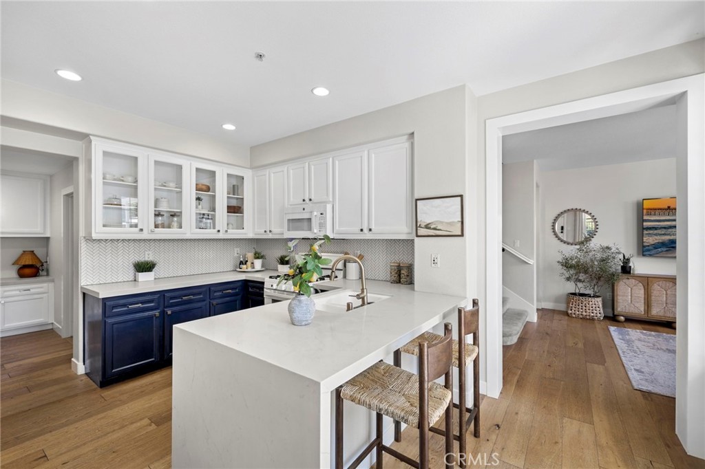 36 Tuberose Street Ladera Ranch, CA 92694 - Photo 15 of 39 a kitchen with a sink a stove cabinets and wooden floor