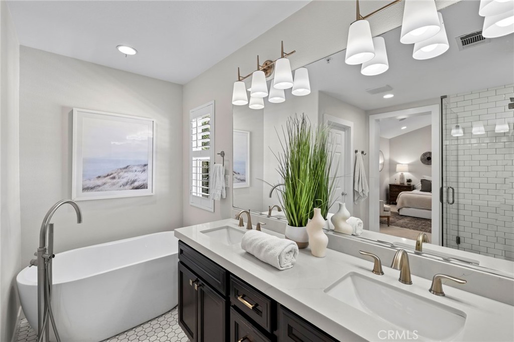 36 Tuberose Street Ladera Ranch, CA 92694 - Photo 28 of 39 a bathroom with a double vanity sink a large mirror and a bathtub