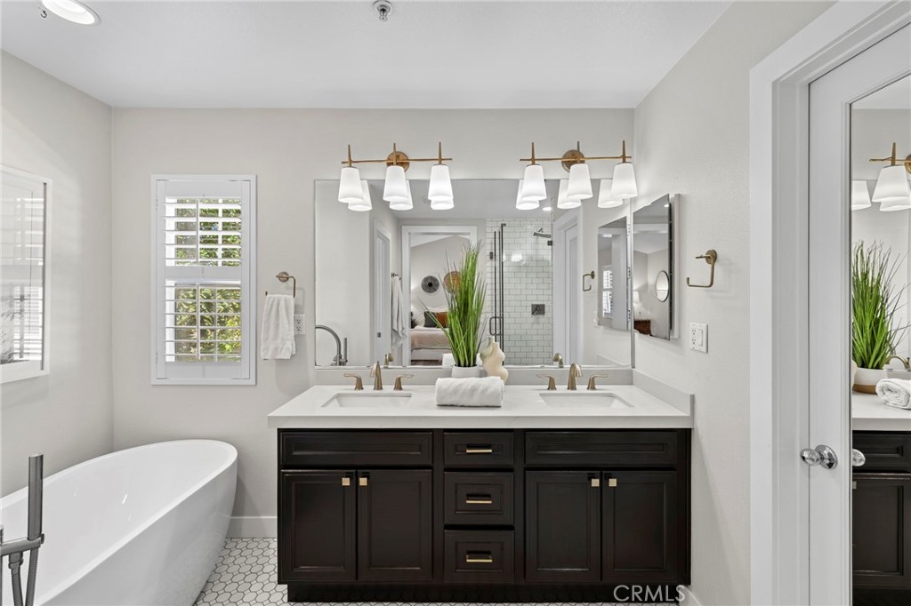 36 Tuberose Street Ladera Ranch, CA 92694 - Photo 30 of 39 a bathroom with a sink double vanity granite tub shower and a mirror