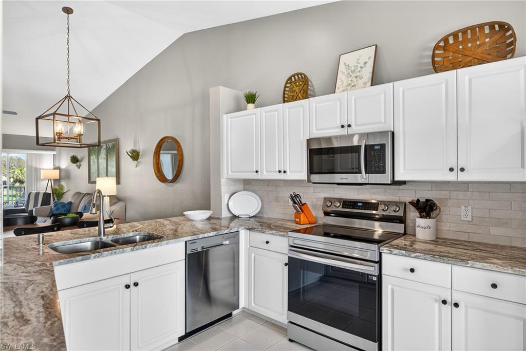 9009 Michael Circle, Unit 4 Naples, FL 34113 - Photo 11 of 34 a kitchen with stainless steel appliances granite countertop a sink a stove and a granite counter tops