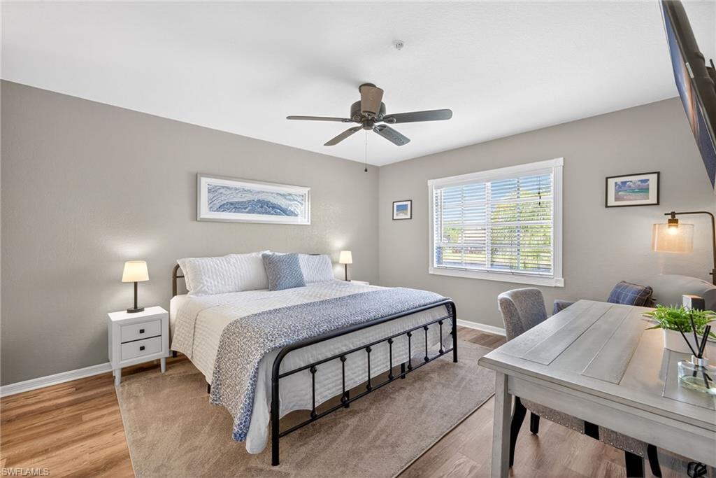 9009 Michael Circle, Unit 4 Naples, FL 34113 - Photo 14 of 34 a bedroom with a bed a chandelier and a table