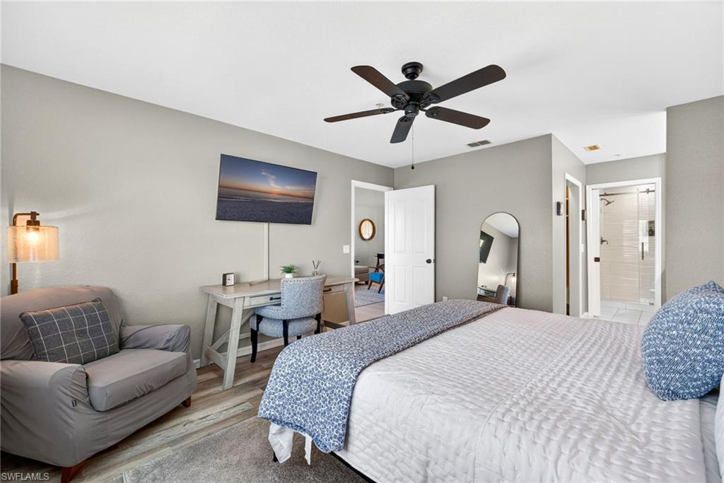 9009 Michael Circle, Unit 4 Naples, FL 34113 - Photo 16 of 34 a spacious bedroom with a bed a couch and a window