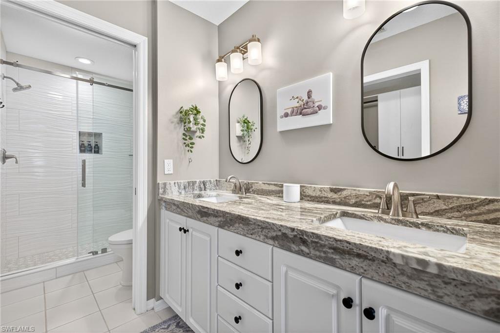9009 Michael Circle, Unit 4 Naples, FL 34113 - Photo 17 of 34 a bathroom with a granite countertop double vanity sink and a mirror