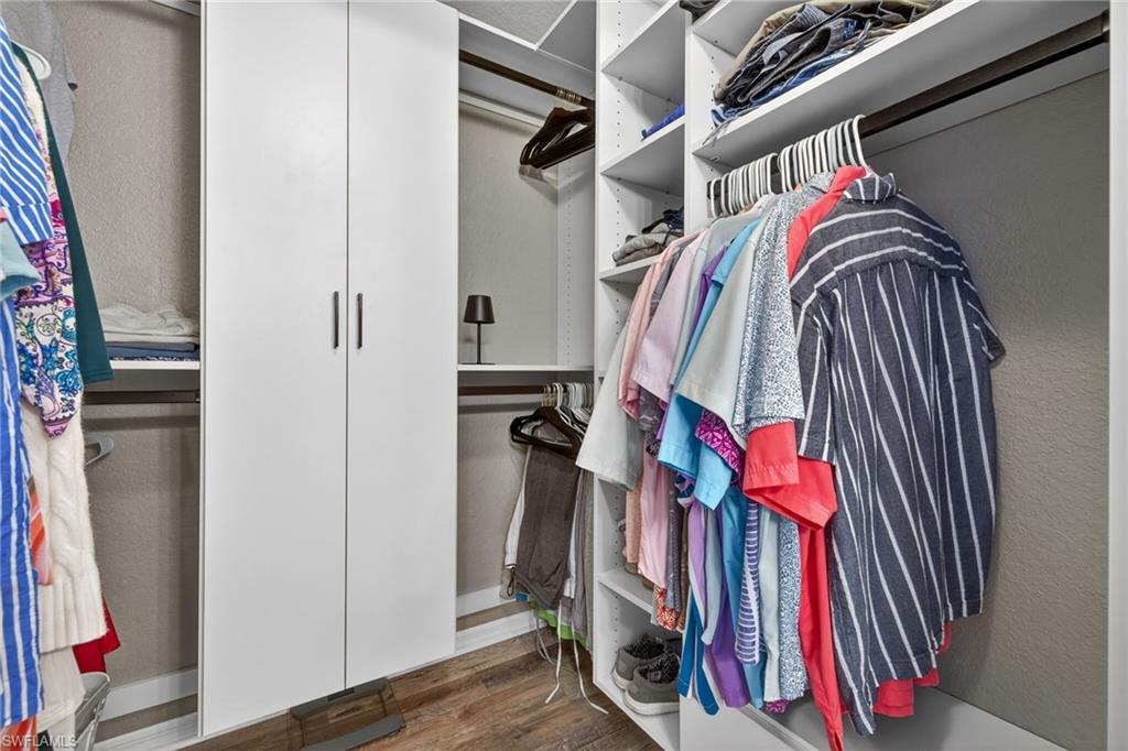 9009 Michael Circle, Unit 4 Naples, FL 34113 - Photo 19 of 34 a view of walk in closet with clothes and shoes