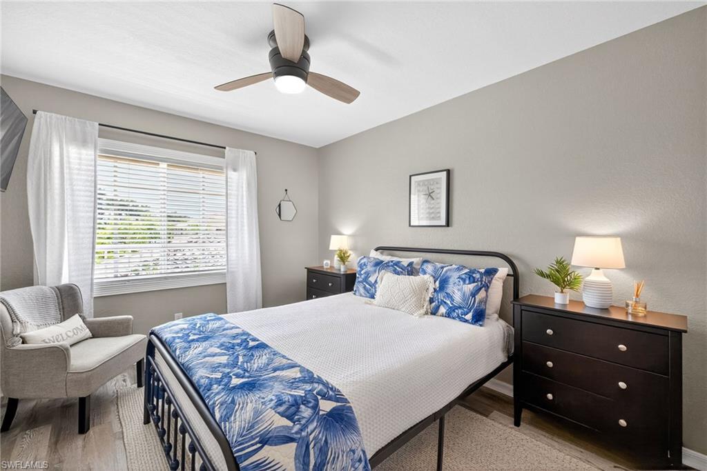 9009 Michael Circle, Unit 4 Naples, FL 34113 - Photo 20 of 34 a bedroom with a bed and a chandelier