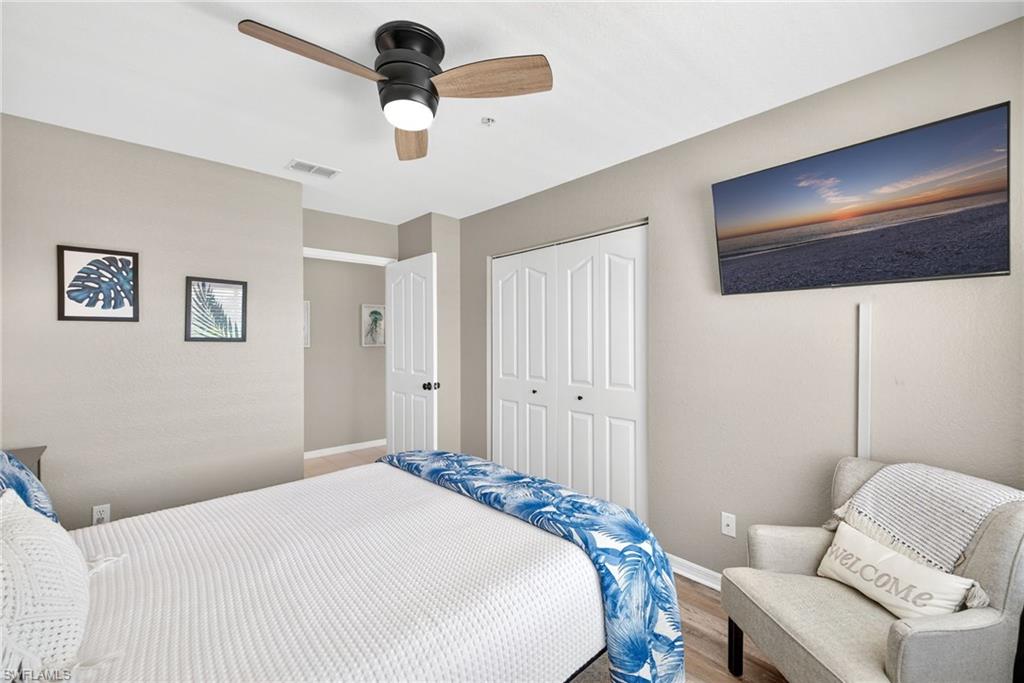 9009 Michael Circle, Unit 4 Naples, FL 34113 - Photo 21 of 34 a bedroom with a bed and a chandelier