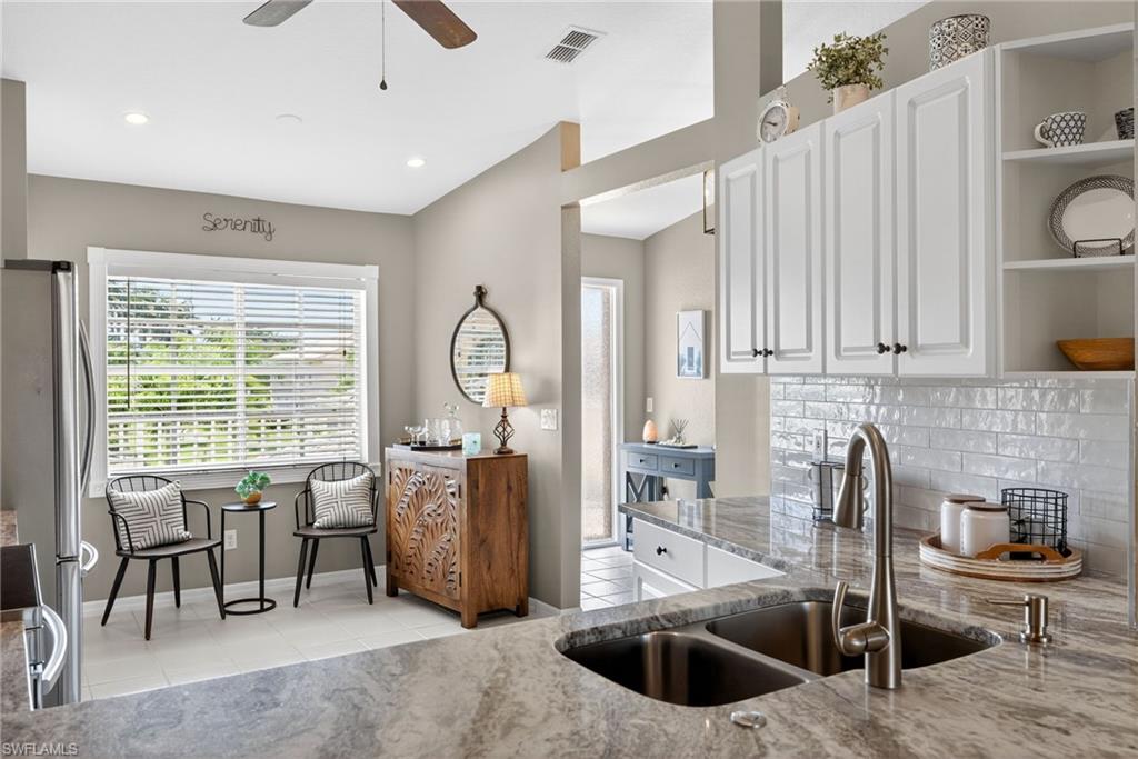 9009 Michael Circle, Unit 4 Naples, FL 34113 - Photo 10 of 34 a view of a kitchen with kitchen island granite countertop a large window cabinets a sink and stainless steel appliances