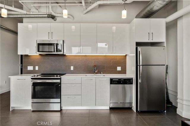 a kitchen with stainless steel appliances and a refrigerator