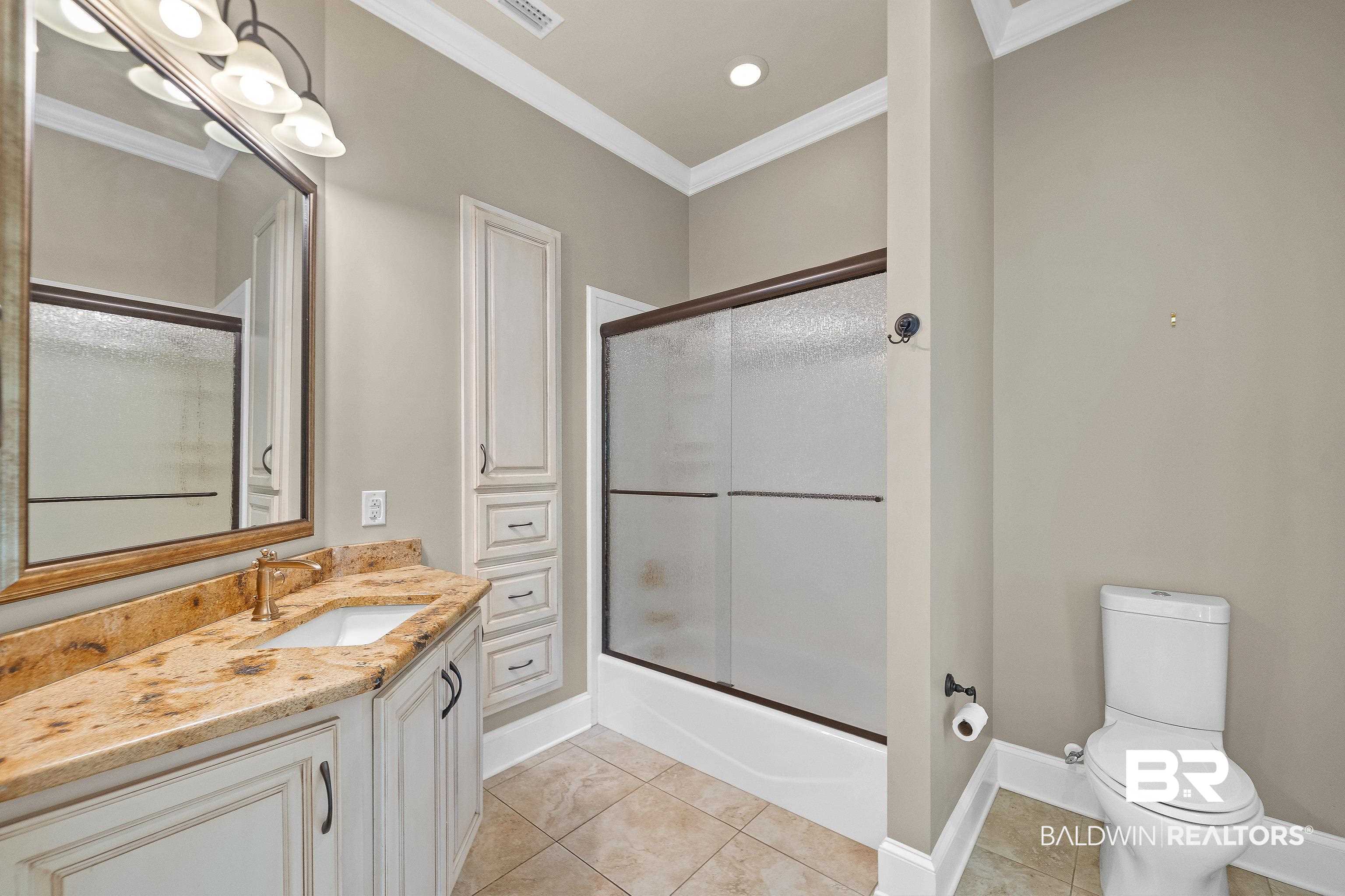 17663 Burwick Loop Fairhope, AL 36532 - Photo 24 of 41 Full bathroom featuring tile patterned flooring, shower / bath combination with glass door, crown molding, vanity, and toilet