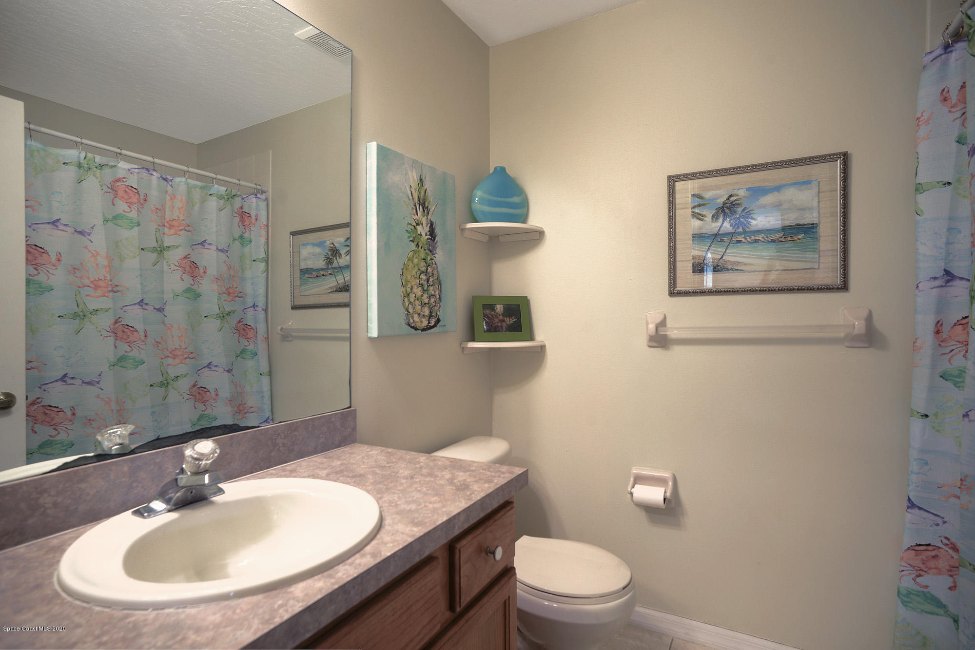 304 Intrepid Way Melbourne, FL 32903 - Photo 25 of 37 a bathroom with a granite countertop toilet a sink and a mirror