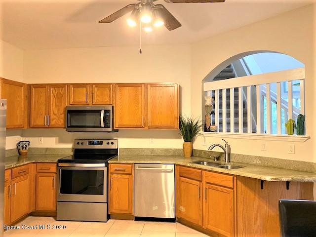 304 Intrepid Way Melbourne, FL 32903 - Photo 4 of 37 a kitchen with stainless steel appliances granite countertop a stove a sink and a microwave