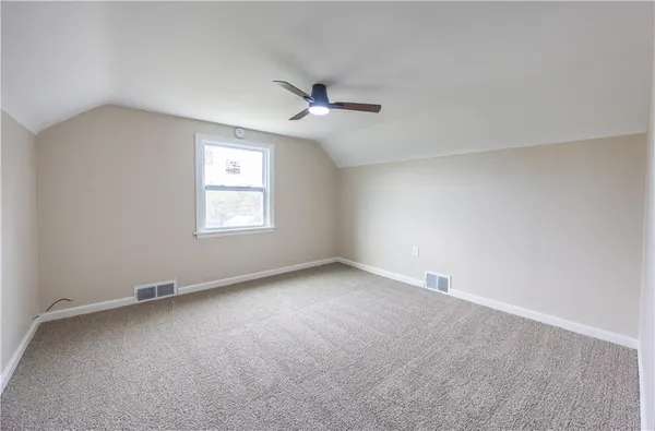 an empty room with a window and ceiling fan