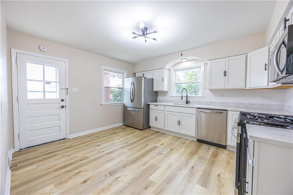 552 Stephens Street Ambridge, PA 15003 - Photo 5 of 21 a kitchen with granite countertop white cabinets and white appliances