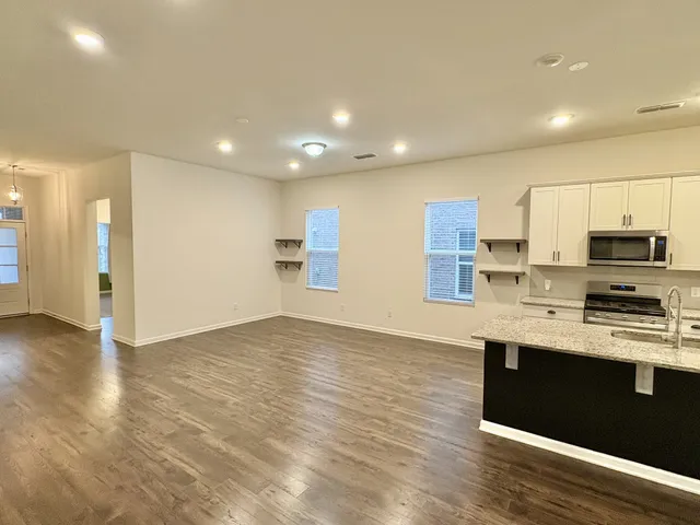 a view of kitchen with stainless steel appliances granite countertop cabinets and wooden floor