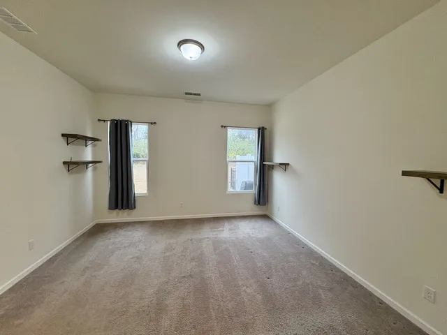 an empty room with windows and closet