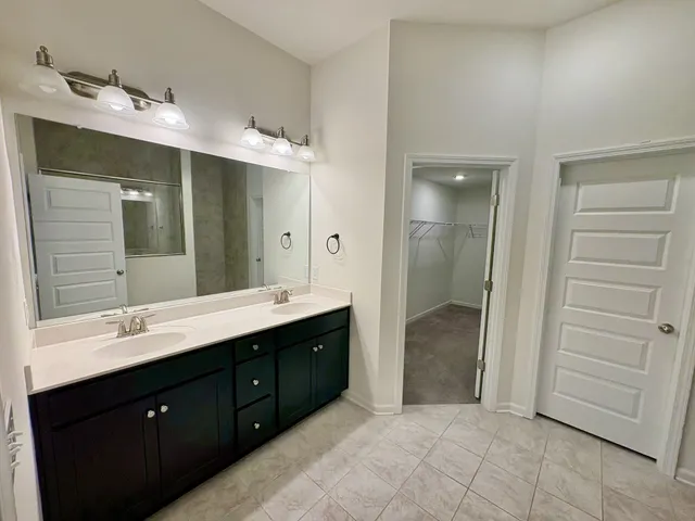 a spacious bathroom with a double vanity sink and a mirror