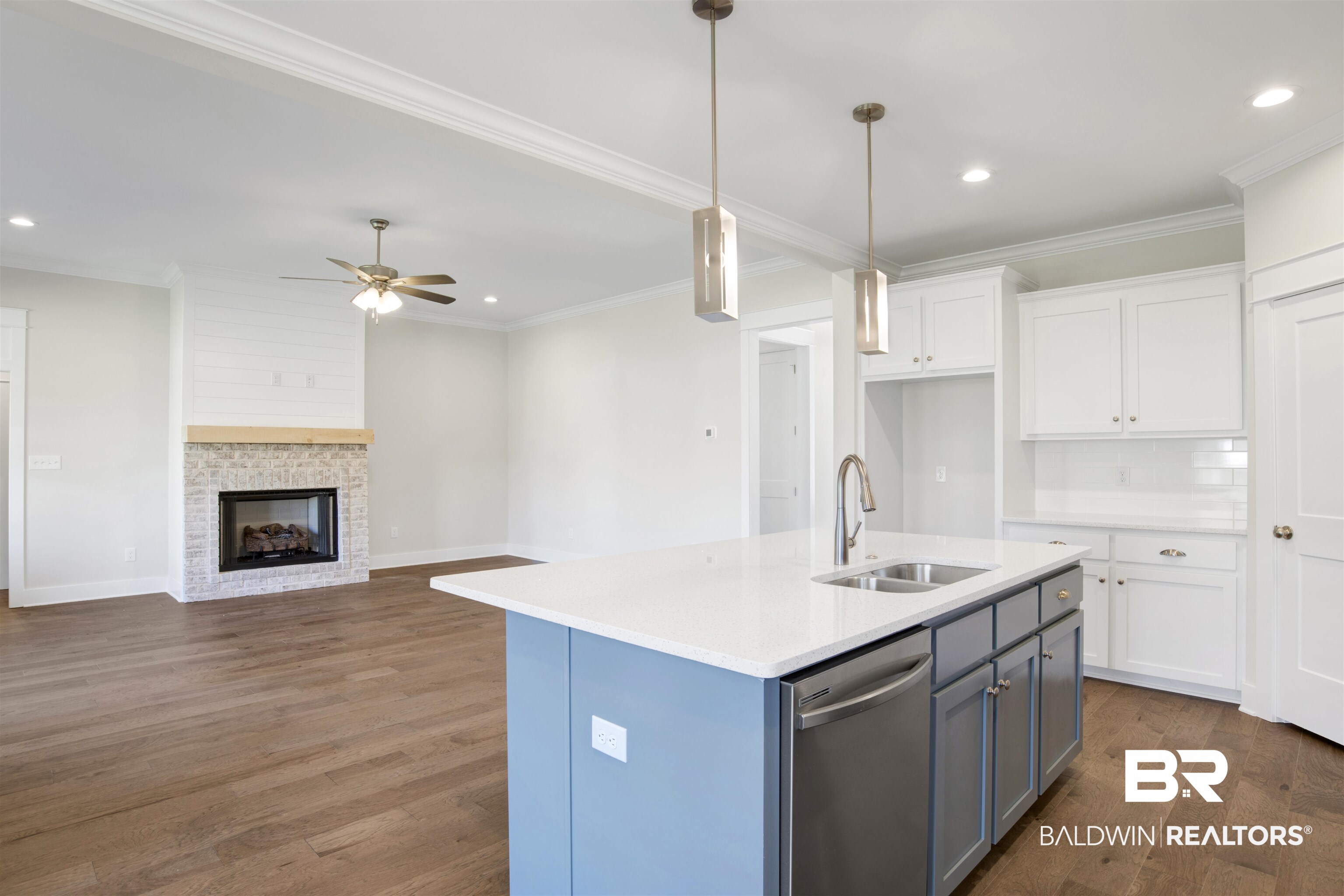 9687 Widgeon Court Daphne, AL 36526 - Photo 15 of 40 Kitchen with a center island with sink, white cabinets, sink, stainless steel dishwasher, and dark hardwood / wood-style floors