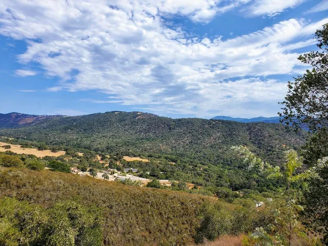 a view of a mountain range with trees in the background