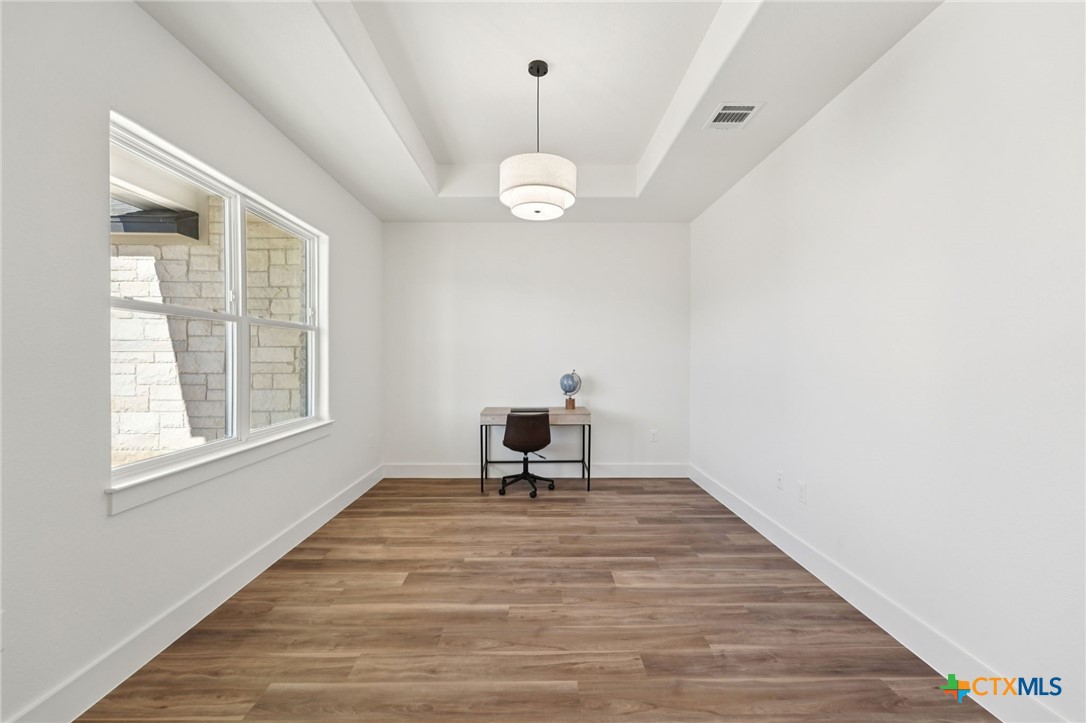 5207 Hollow Ranch Drive Salado, TX 76571 - Photo 16 of 37 a living room with wooden floor windows and a ceiling fan