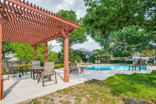 a view of a swimming pool with lawn chairs and couches