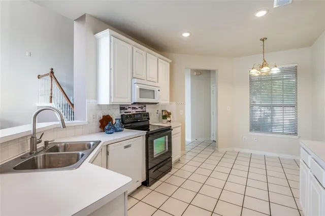 a kitchen with a sink a stove cabinets and a counter top space