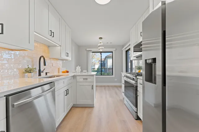 a kitchen with white cabinets and appliances