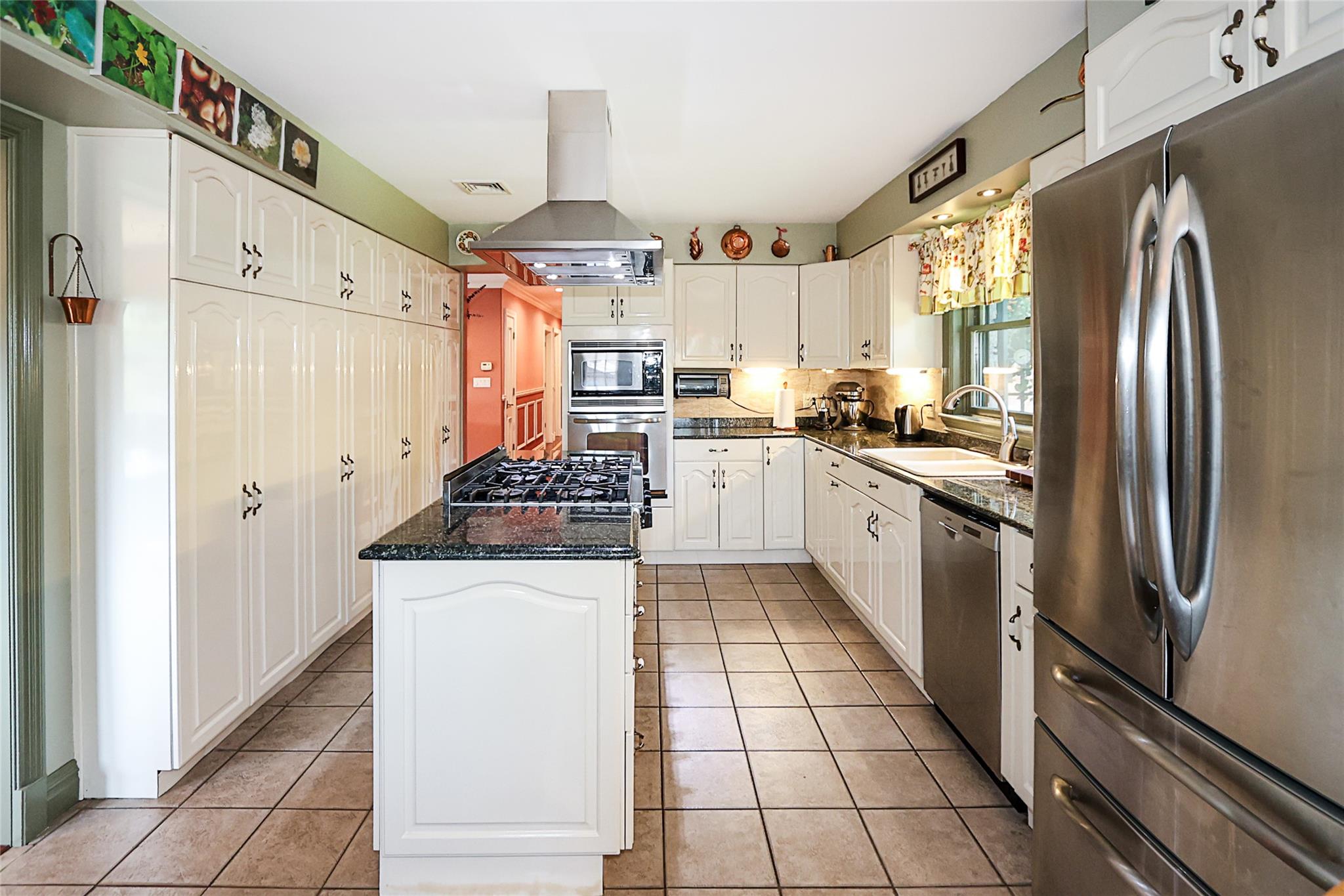 19 Marietta Road Glen Cove, NY 11542 - Photo 14 of 46 a kitchen with stainless steel appliances granite countertop a refrigerator a sink and white cabinets