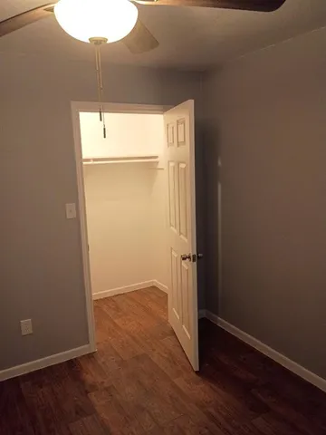 an empty room with wooden floor cabinet and closet