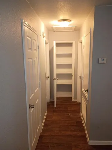 a view of a hallway with wooden floor and closet