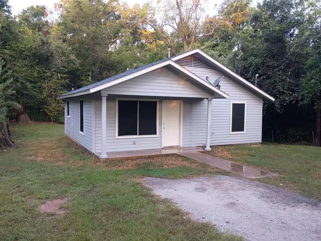 a front view of a house with a garden and yard