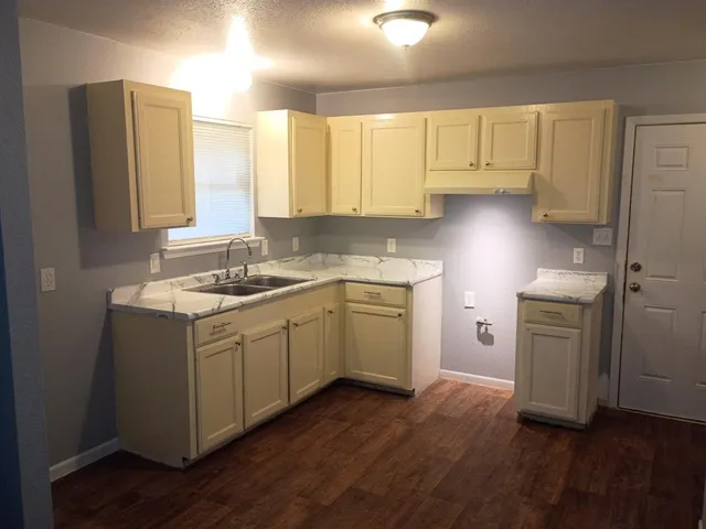 a kitchen with a sink cabinets stainless steel appliances and a window